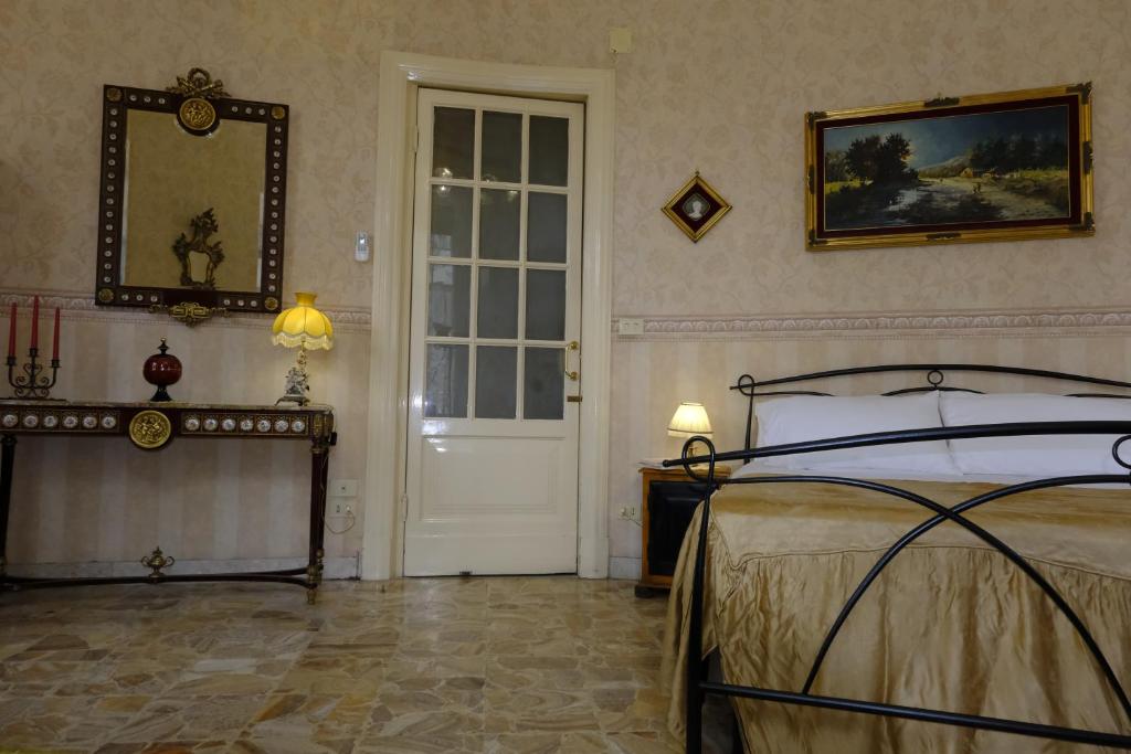 1 dormitorio con cama y puerta blanca en Palazzo Vitrano - tourist apartment, en Catania