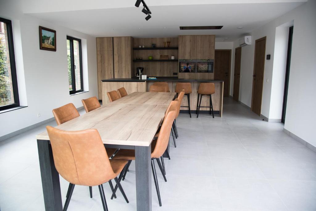 a dining room with a wooden table and chairs at Vakantiewoning Den Appel in Dendermonde