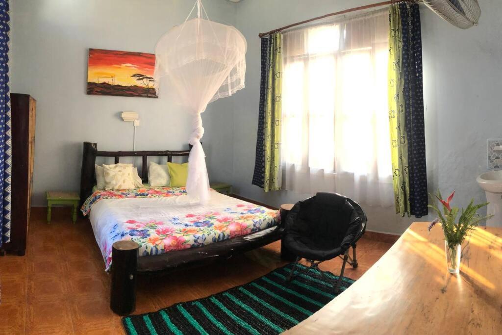 - une chambre avec un lit et une fenêtre dans l'établissement the APARTMENT house, à Mbale