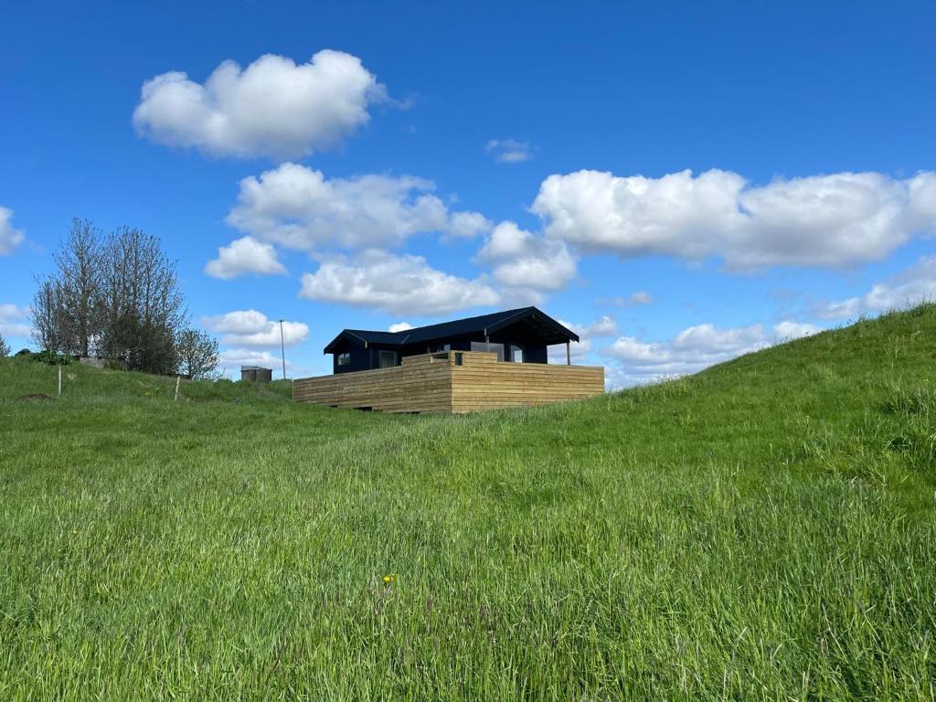 una casa en una colina en un campo de hierba en Iceland Inn Cabin, en Selfoss