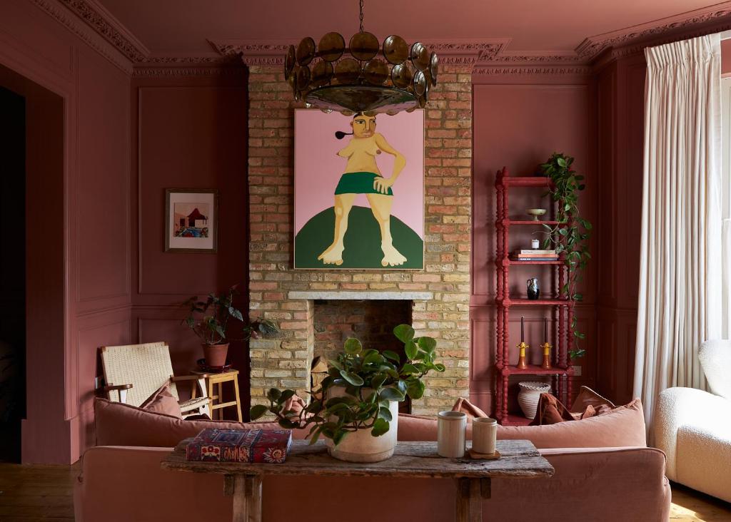 een woonkamer met een open haard en een schilderij van een vrouw bij Margate House in Kent
