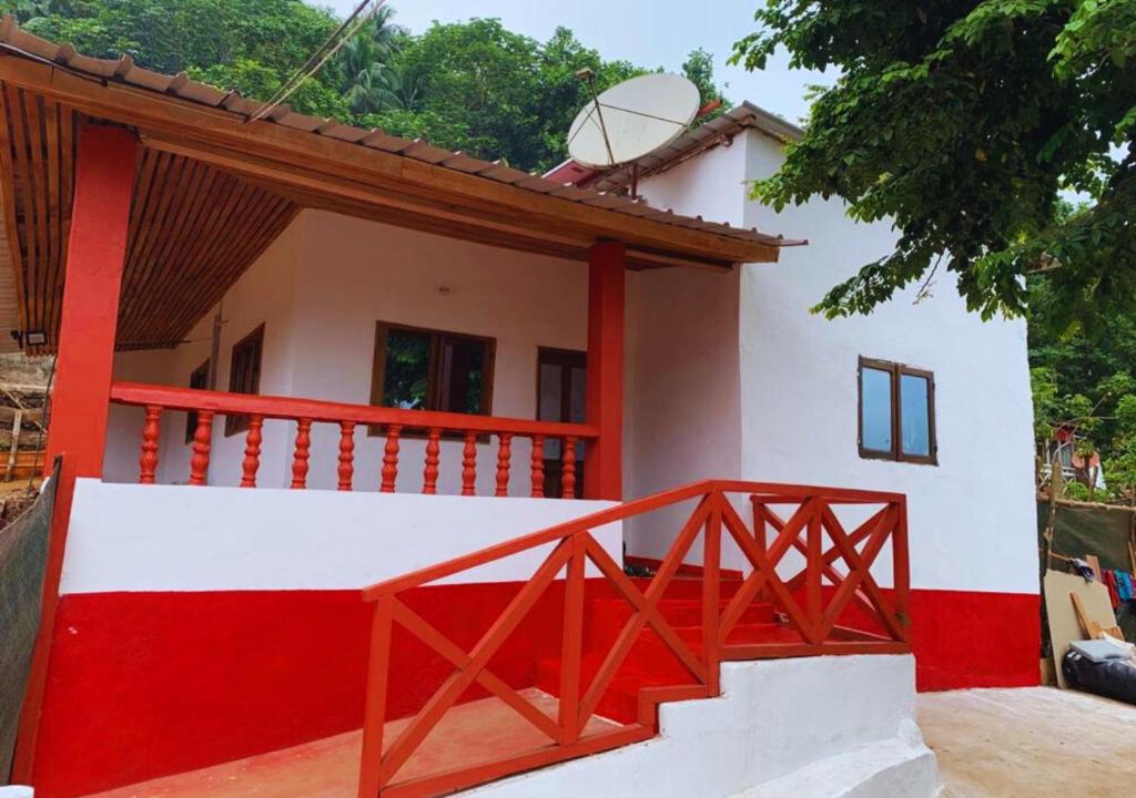 een klein huis met een rood en wit bij Ilhéu Castle in Ilheu das Rolas