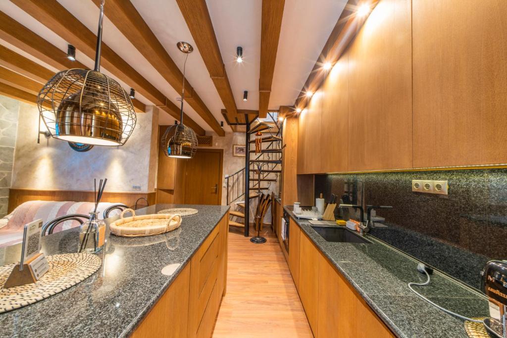 une grande cuisine avec des placards en bois et des comptoirs noirs dans l'établissement Pirin Golf&Spa Apartment 17, à Razlog