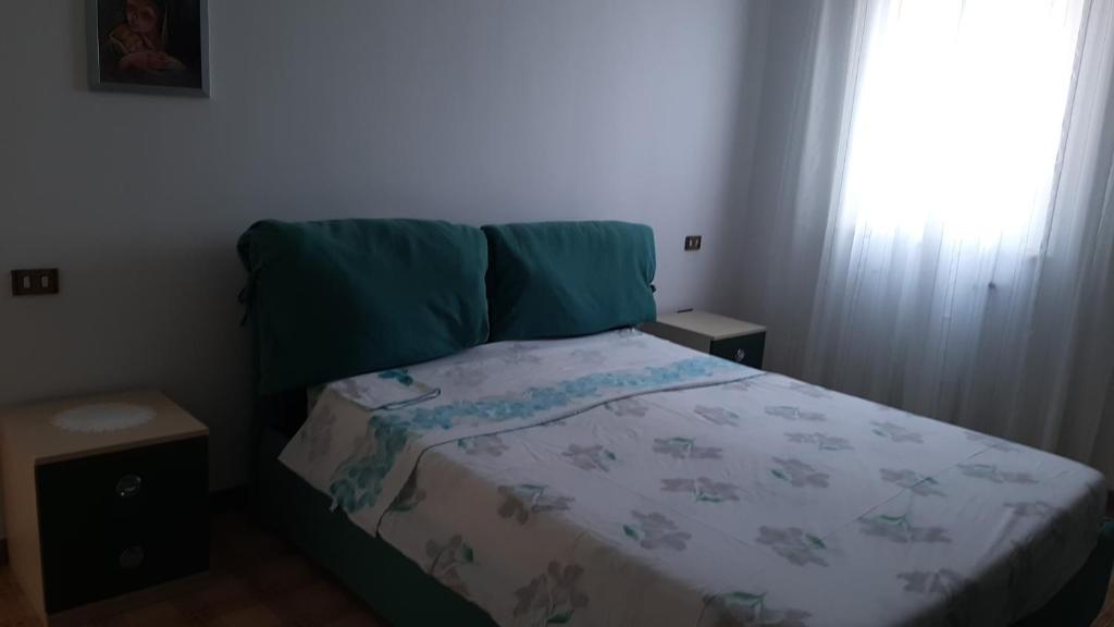 ein kleines Schlafzimmer mit einem Bett mit einer Decke und einem Fenster in der Unterkunft Dimora Chiara 