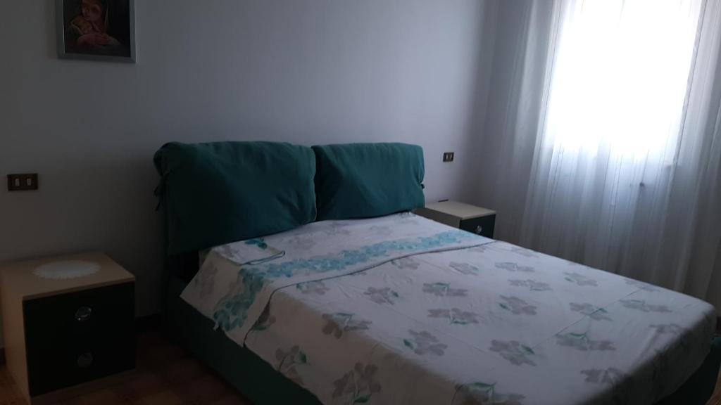 a small bedroom with a bed with a blanket and a window at Dimora Chiara in SantʼAngelo