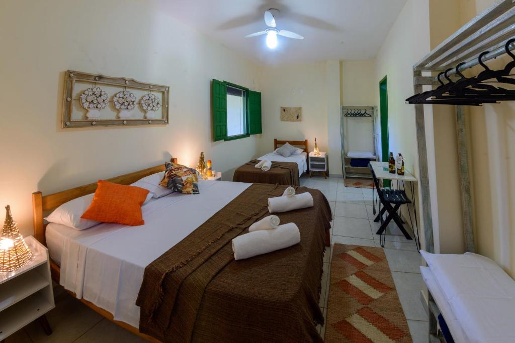 um quarto com 2 camas e toalhas em Casarão das artes hospedaria em Cumuruxatiba