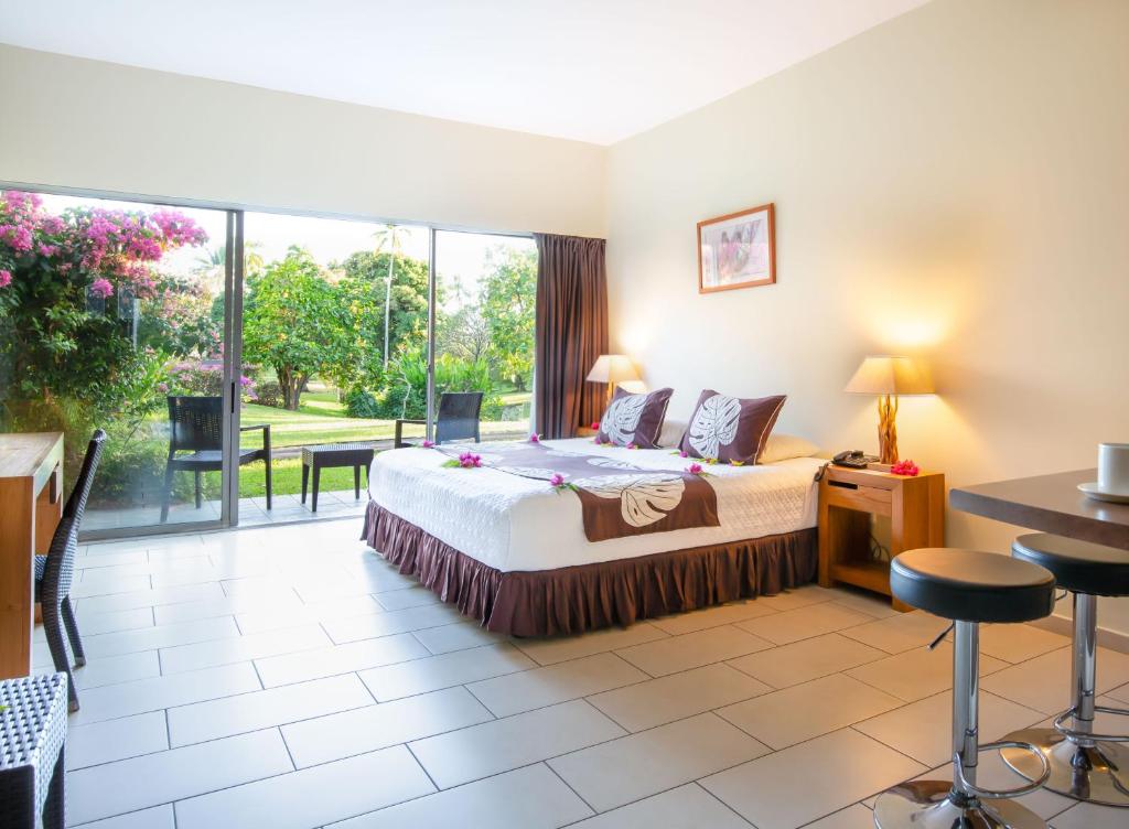 Habitación de hotel con cama y ventana grande en Royal Tahitien, en Papeete