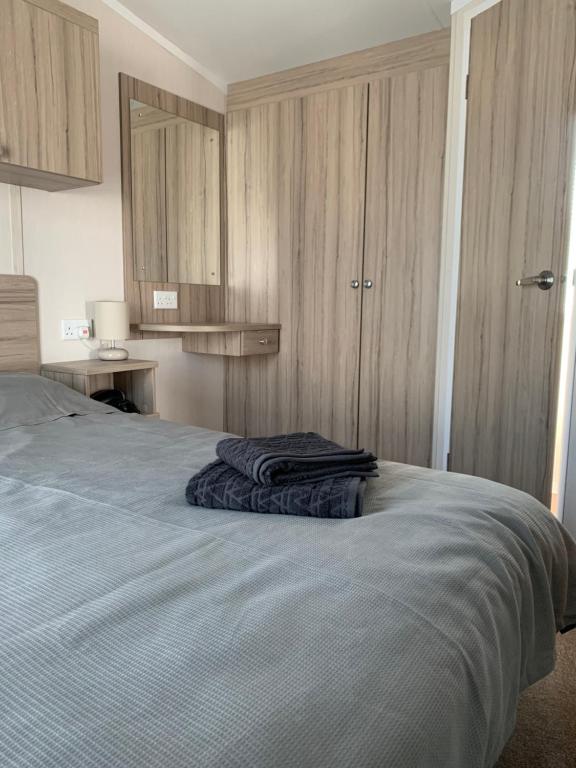 Un dormitorio con una cama con una manta azul. en Hot tub breakaways with castle view en Lincolnshire