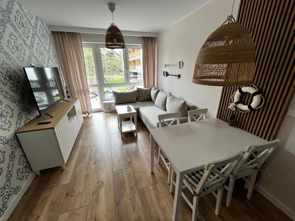 uma sala de estar com uma mesa e um sofá em Apartament Szumilas Rowy em Rowy