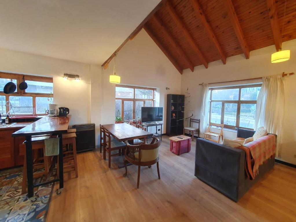 een keuken en woonkamer met een tafel en een bank bij CASA DE LA LAGUNA in Ushuaia
