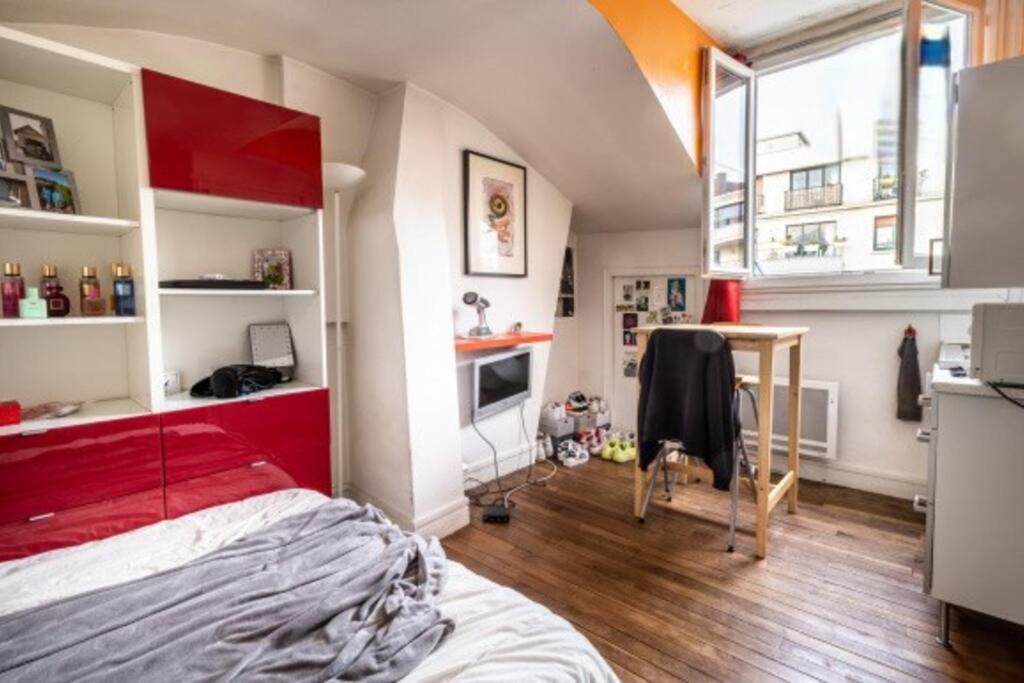 um quarto com uma cama vermelha num quarto em Penthouse by Roland-Garros em Boulogne-Billancourt