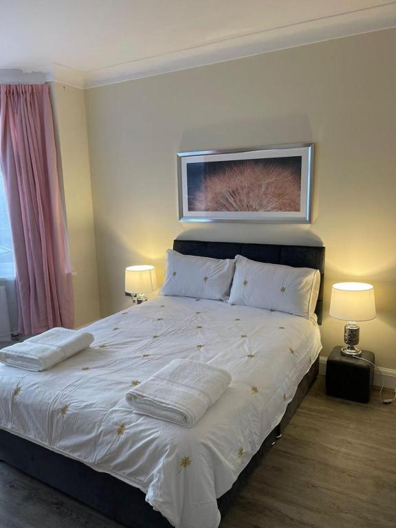 sypialnia z dużym białym łóżkiem z 2 lampami w obiekcie 4 Bed Family Home w mieście Woodford Green