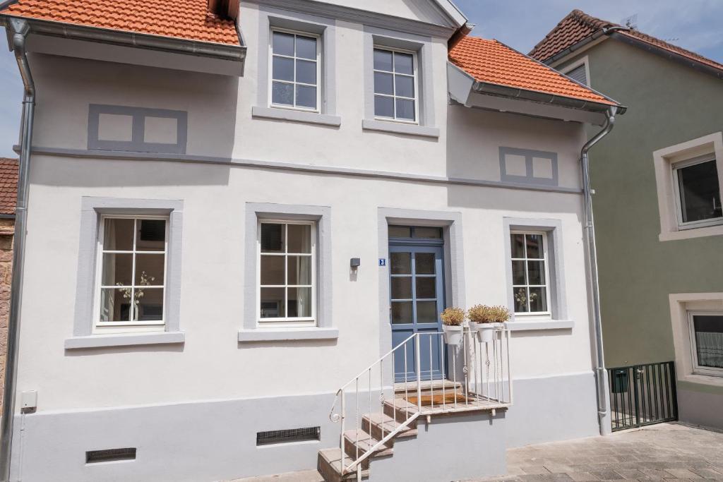 a white facade of a house with a balcony at FREYZEIT Häuschen in Wachenheim an der Weinstraße in Wachenheim an der Weinstraße