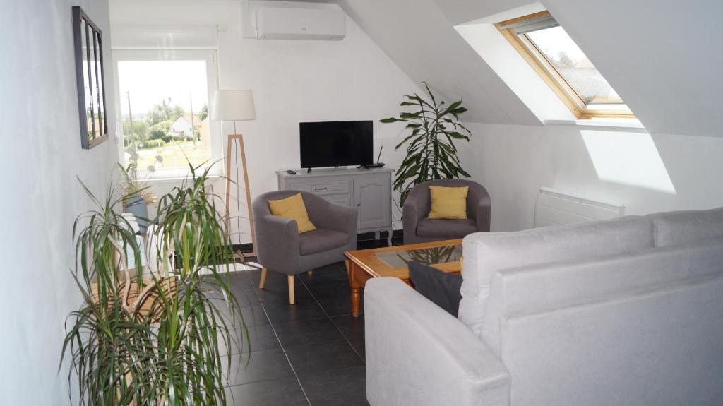 a living room with a couch and chairs and a tv at Sur la route des Monts in Bailleul