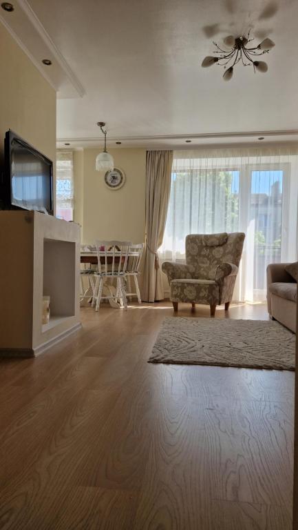 a living room with a couch and a tv at Cozy centre apartment KKE in Ventspils