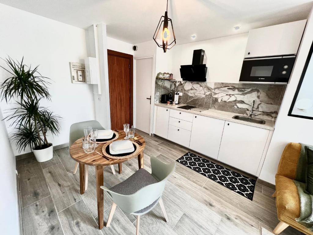 une cuisine et une salle à manger avec une table et des chaises dans l'établissement Le Ravello proche gare PARTDIEU, à Lyon