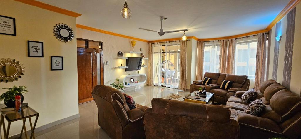 a living room with two couches and a tv at Betty Homes in Mombasa