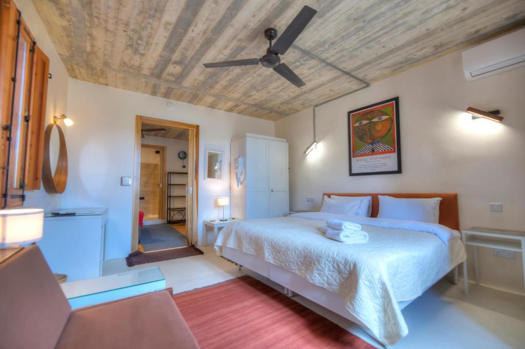 a bedroom with a bed and a ceiling fan at Independent Old House in Gozo With Modernized Interior in Munxar