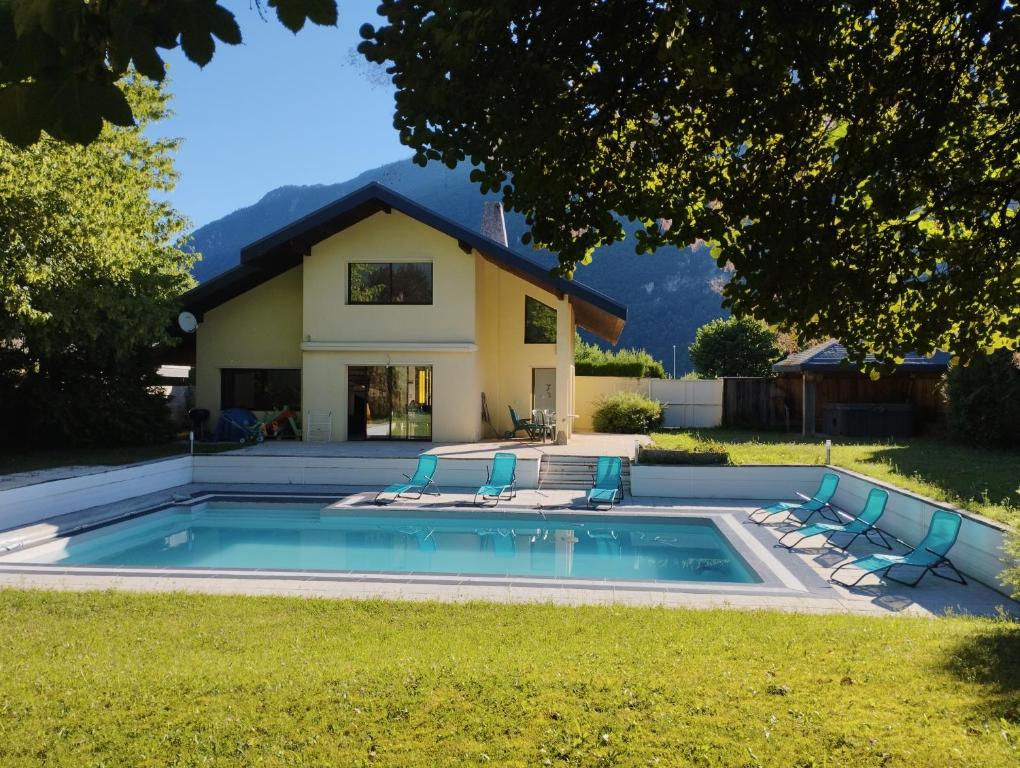 a swimming pool in front of a house at Villa Armonia, piscine chauffée, jacuzzi et jardin à 5mn du lac d Annecy in Doussard