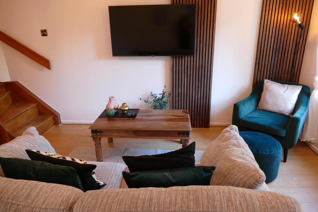 a living room with a couch and a table and a tv at Home in Longwell Green in Warmley