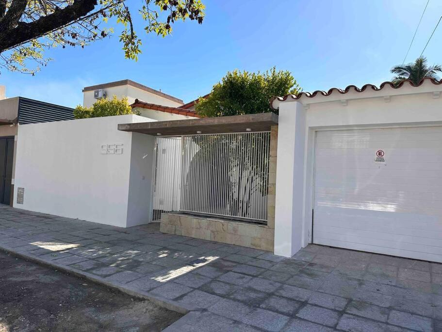 a house with a white fence and a garage at CASA CUTI in Reconquista