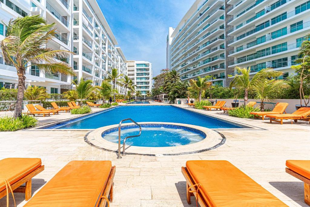 a swimming pool in a resort with tables and benches at Morros 3 in Cartagena de Indias