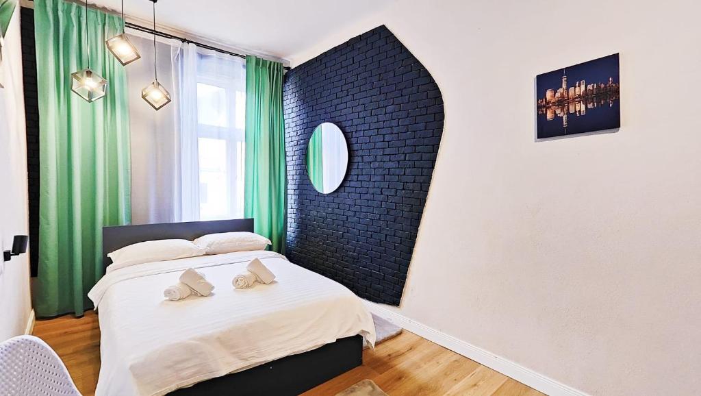 1 dormitorio con 1 cama y una ventana con cortinas verdes en Bridge View Studio, en Sibiu