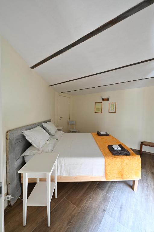 a bedroom with a large bed and a table at CASCINA BINELLO in Murazzano