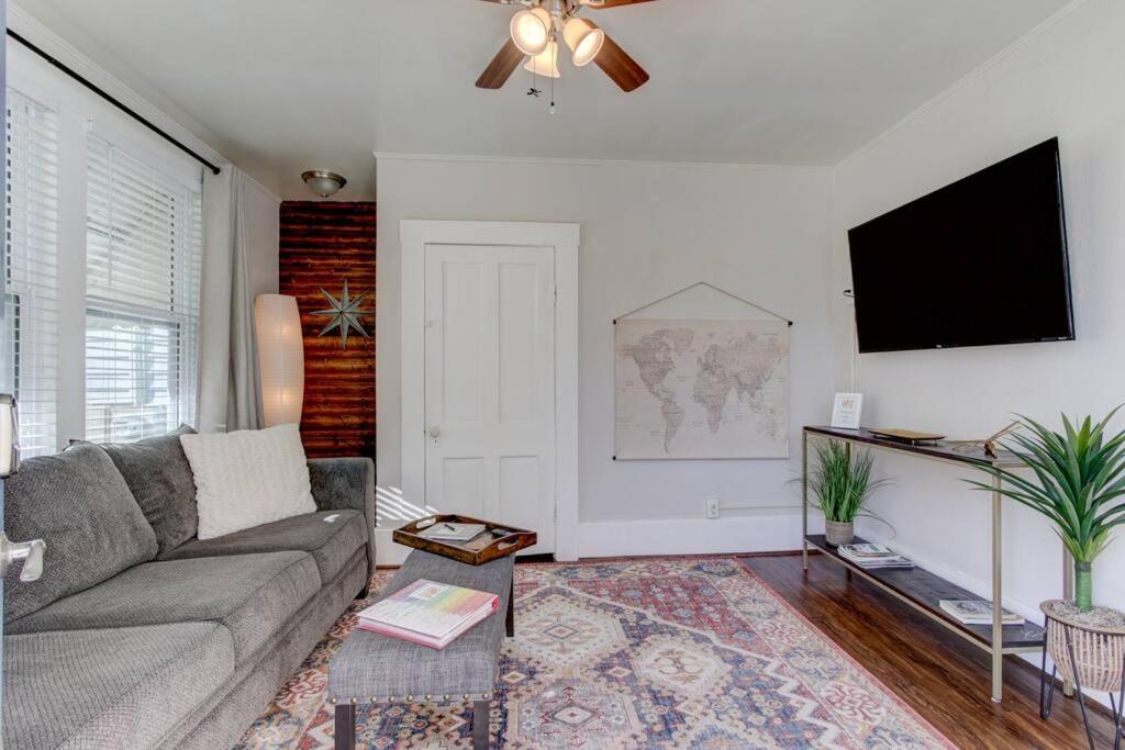 a living room with a couch and a flat screen tv at Cedar Blossom Bungalow is a cozy getaway with a 5 minute walk to downtown! in Hot Springs
