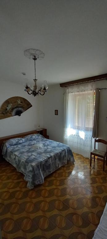 1 dormitorio con cama y lámpara de araña en Casa Pako en Tortora