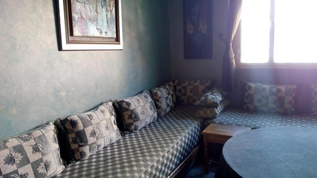 een woonkamer met een bank en een tafel bij Appartement 05 in Temara