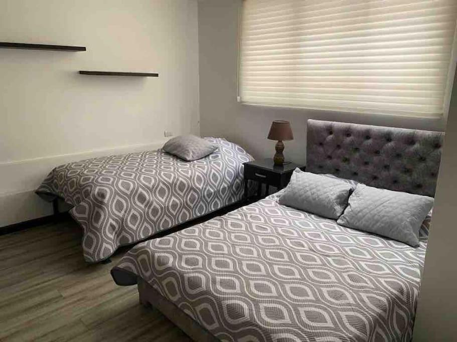 dwa łóżka siedzące obok siebie w sypialni w obiekcie Departamento entero sector Oro Verde w mieście Cuenca