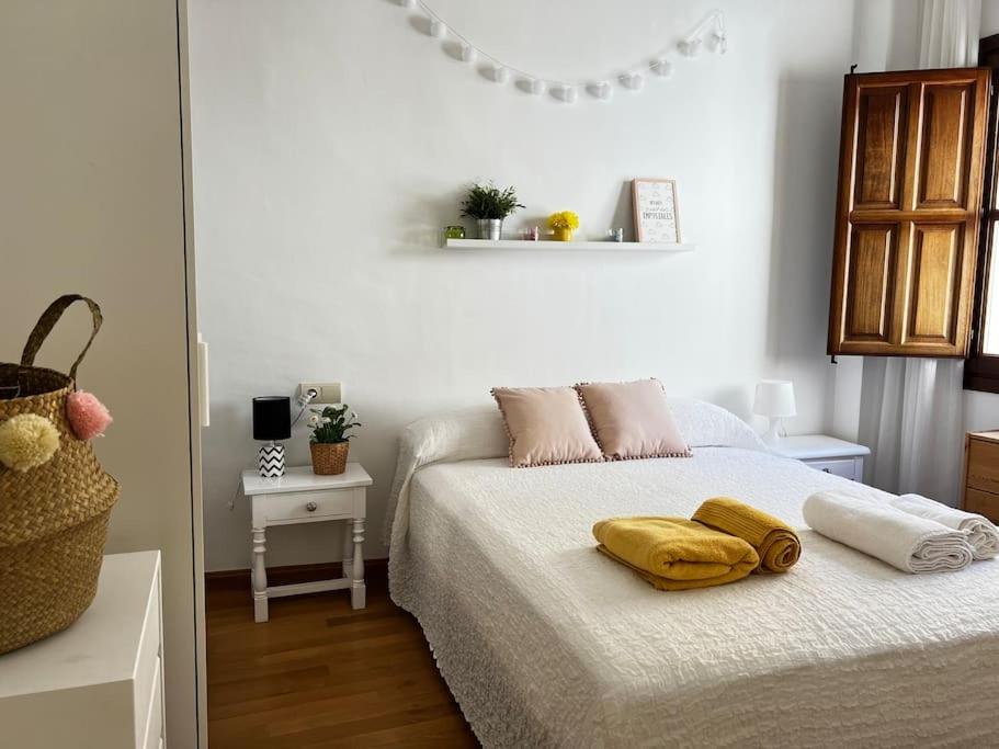 een slaapkamer met een bed met twee handdoeken erop bij Apartamento muy céntrico en Granada in Granada