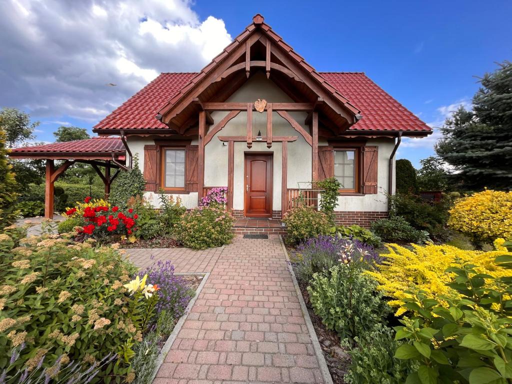 une petite maison avec un toit rouge et une passerelle en briques dans l'établissement Ignacówka, à Kobyla Góra