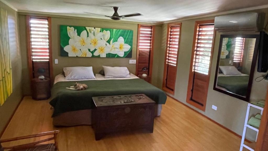 a bedroom with a bed and a painting of flowers at Luxury in Wailoaloa in Nadi
