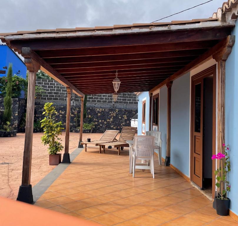 eine überdachte Terrasse mit einer Bank und einem Tisch in der Unterkunft VV Casa Carmela Talavera in Barlovento