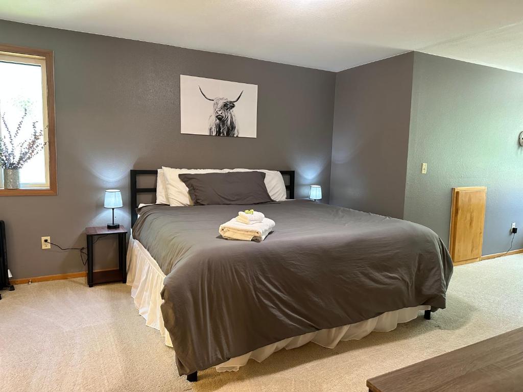 um quarto com uma cama com uma imagem de vaca na parede em Urban Farmhouse- KING bed! em Corvallis