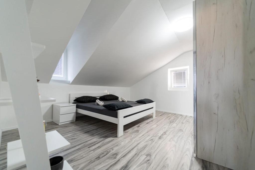 ein Schlafzimmer mit einem Bett in einem weißen Zimmer in der Unterkunft City Center Mayess Aparment in Zadar