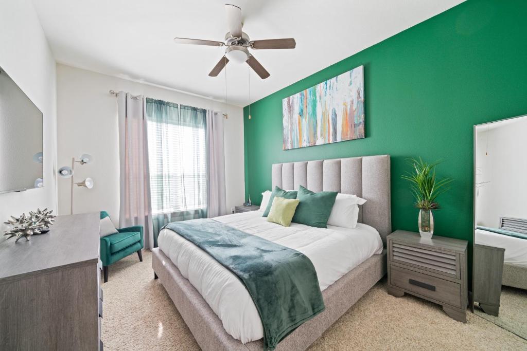 a bedroom with a large bed with a green wall at Packhouse 3 in Houston