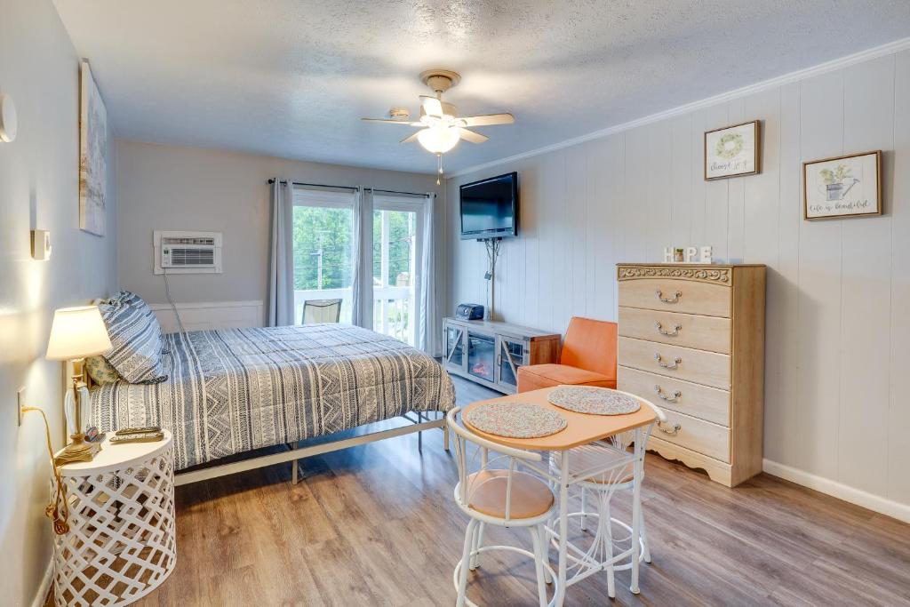 een slaapkamer met een bed, een tafel en een stoel bij Fayetteville Vacation Rental with Balcony! in Fayetteville