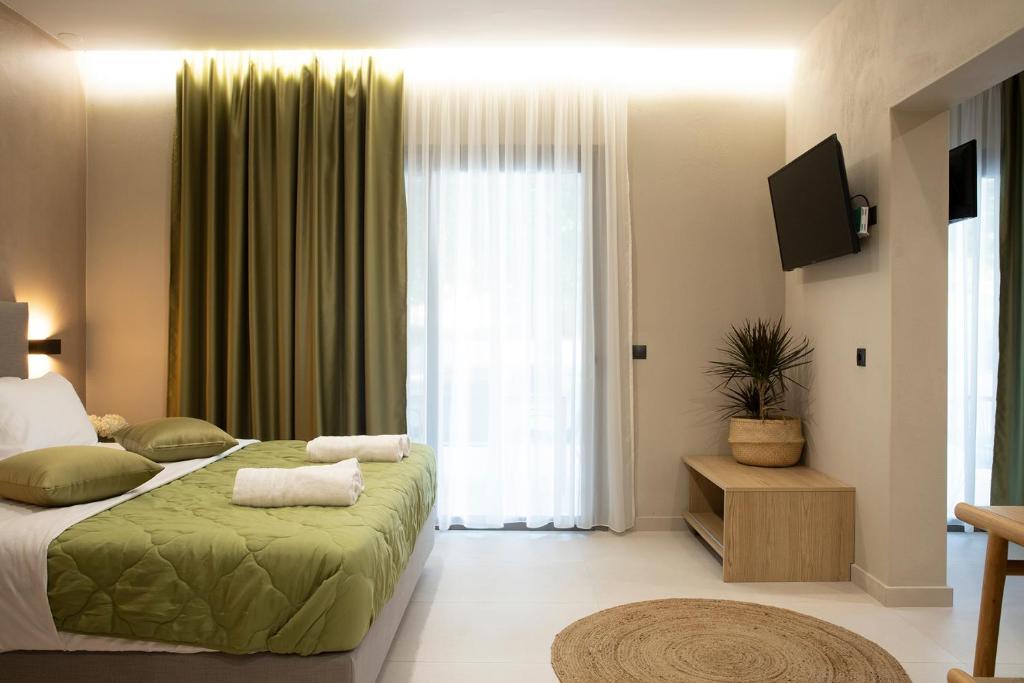 a bedroom with a bed and a large window at Olympus Suites in Paralia Panteleimonos