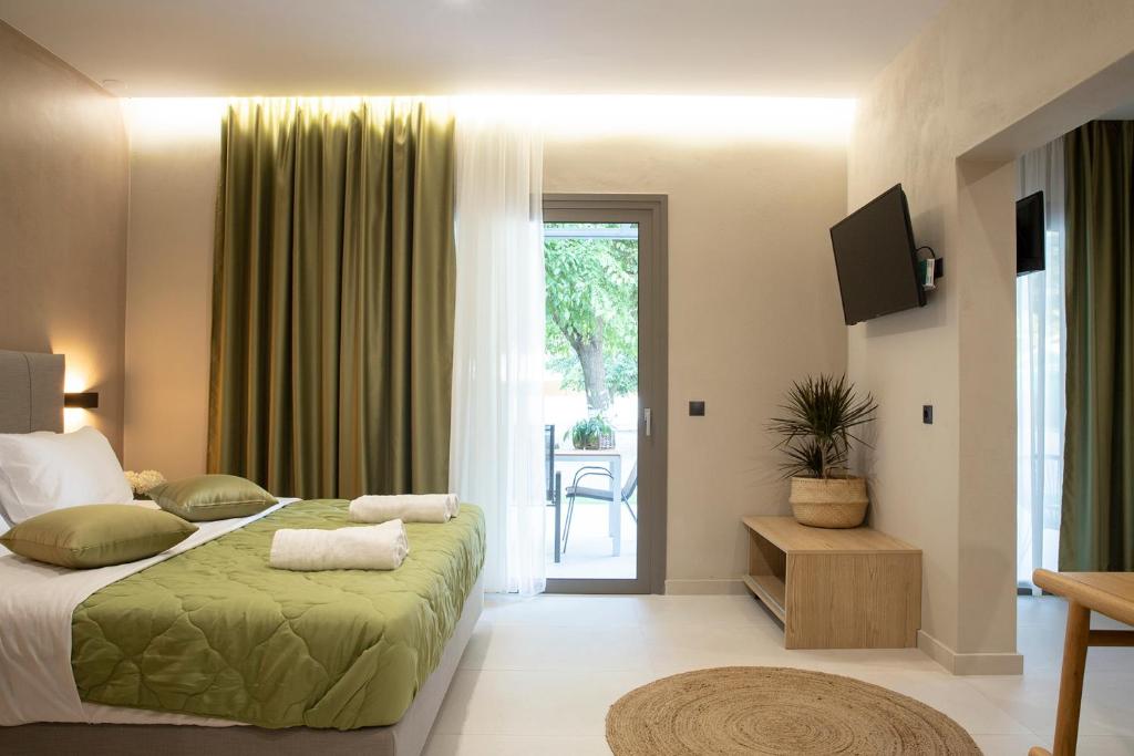 a bedroom with a bed and a sliding glass door at Olympus Suites in Paralia Panteleimonos