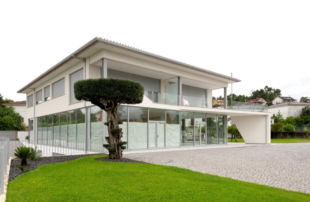 una casa con un árbol delante de ella en Sun House - Alojamento Local - Ponte de Lima, en Ponte de Lima