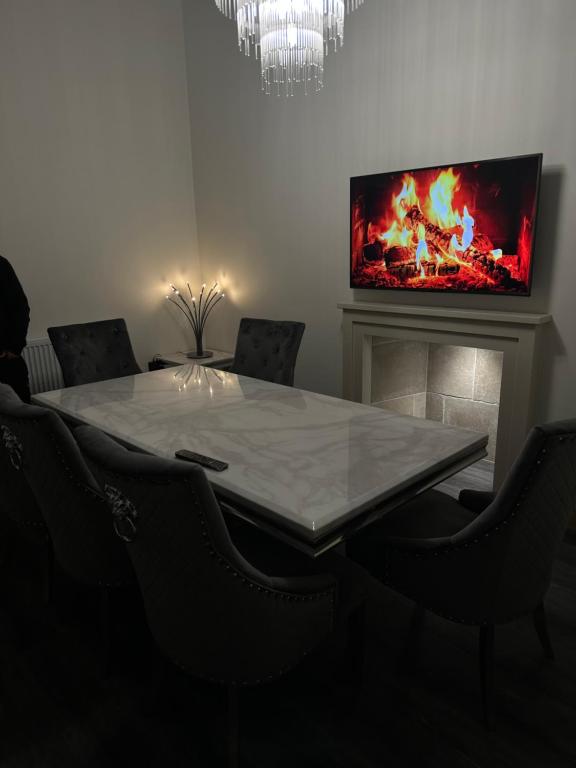 a dining room with a table and a tv on the wall at Thistle City Inn in Edinburgh