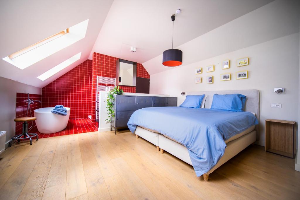 Casa Mina - Dok Noord Ghent في خنت: غرفة نوم بسرير وجدار احمر