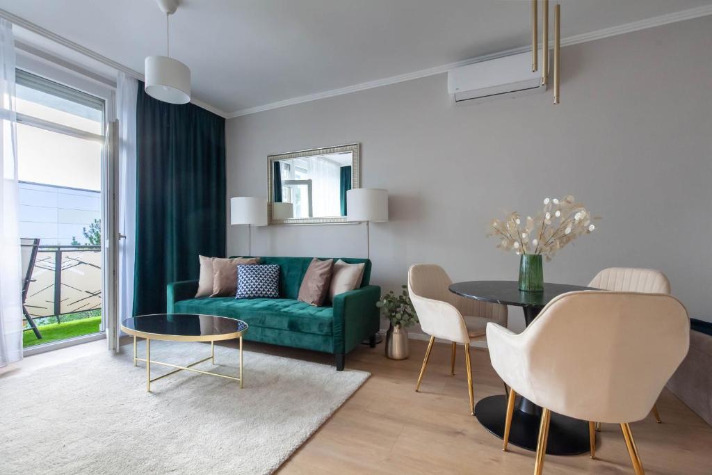 SMARAGD-Emerald في فيسبرم: غرفة معيشة مع أريكة خضراء وطاولة