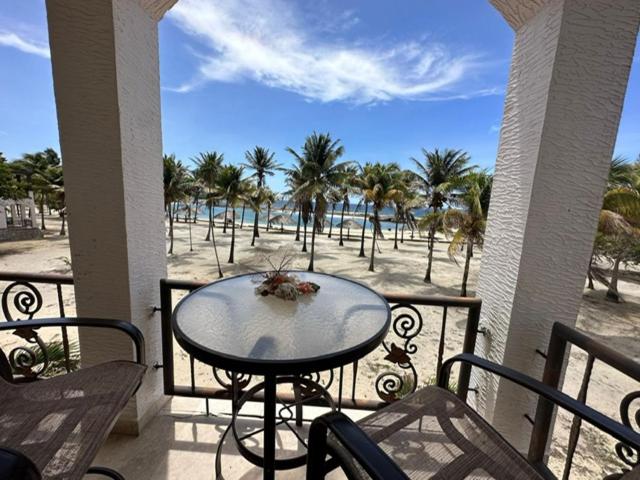 una mesa en un balcón con vistas a la playa en Beach Front Condo steps from beach en Six Huts