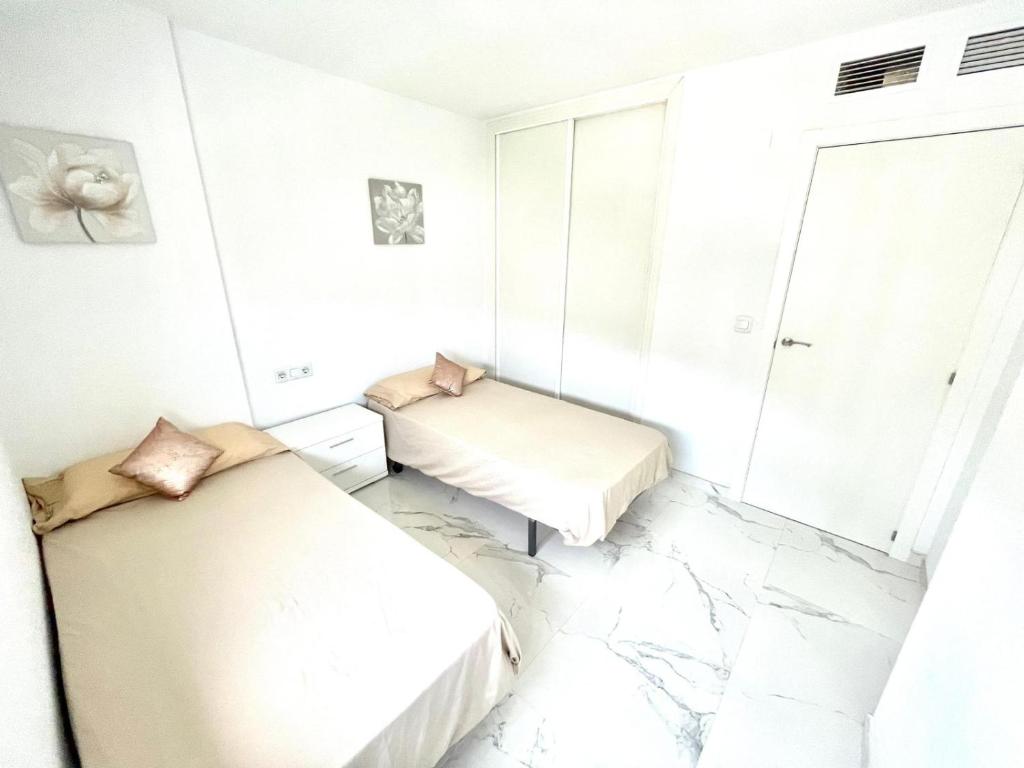 2 łóżka w pokoju z marmurową podłogą w obiekcie Apartamento Benidorm Rincón de Loix w mieście Benidorm