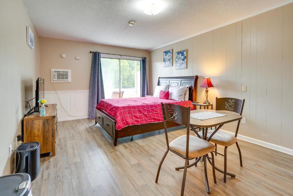 Schlafzimmer mit einem Bett, einem Tisch und Stühlen in der Unterkunft New River Gorge Vacation Rental with Balcony! in Fayetteville