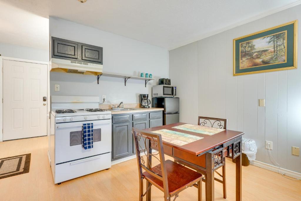 Il comprend une cuisine équipée d'une table et d'une cuisinière. dans l'établissement Nifty Fayetteville Vacation Rental Near New River!, à Fayetteville